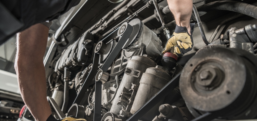 A man repairs a vehicle's engine