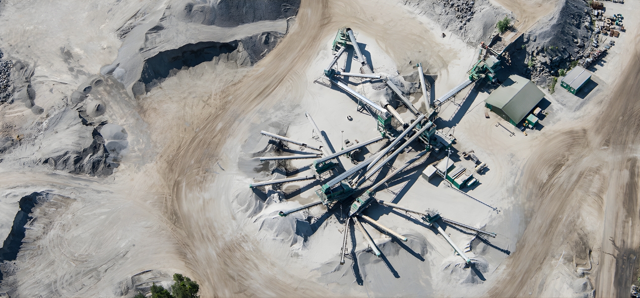 Aerial view of a large quarry featuring a significant sand pile and Scania industrial power system equipment.