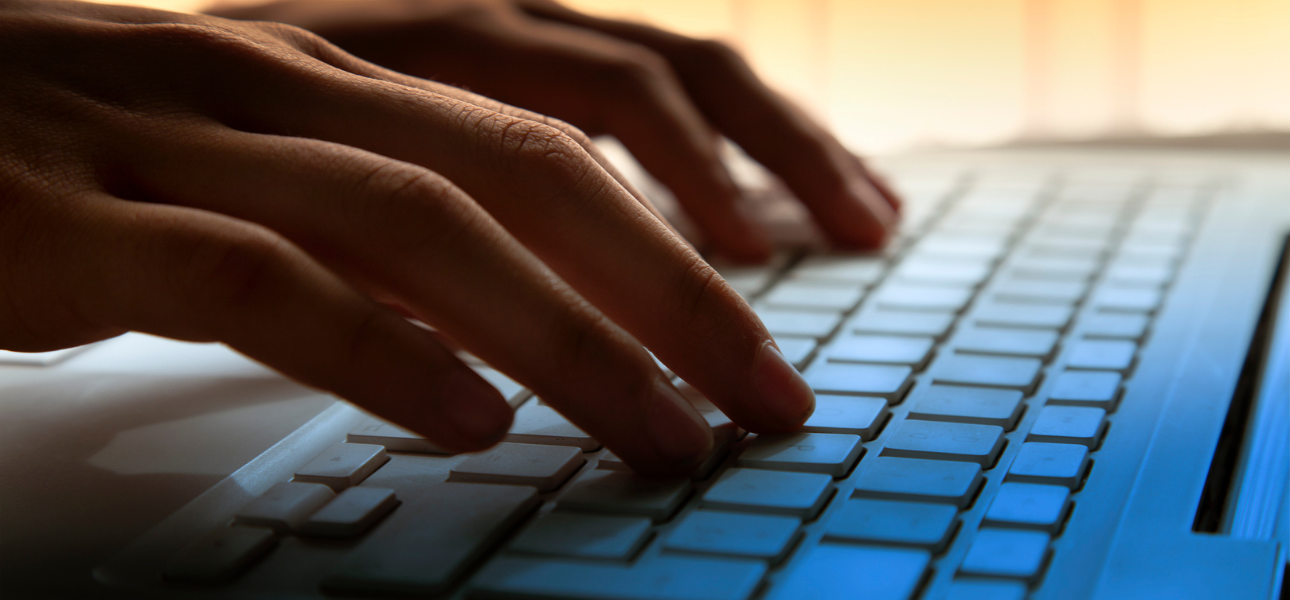 Close-up of a person’s hands typing on a keyboard