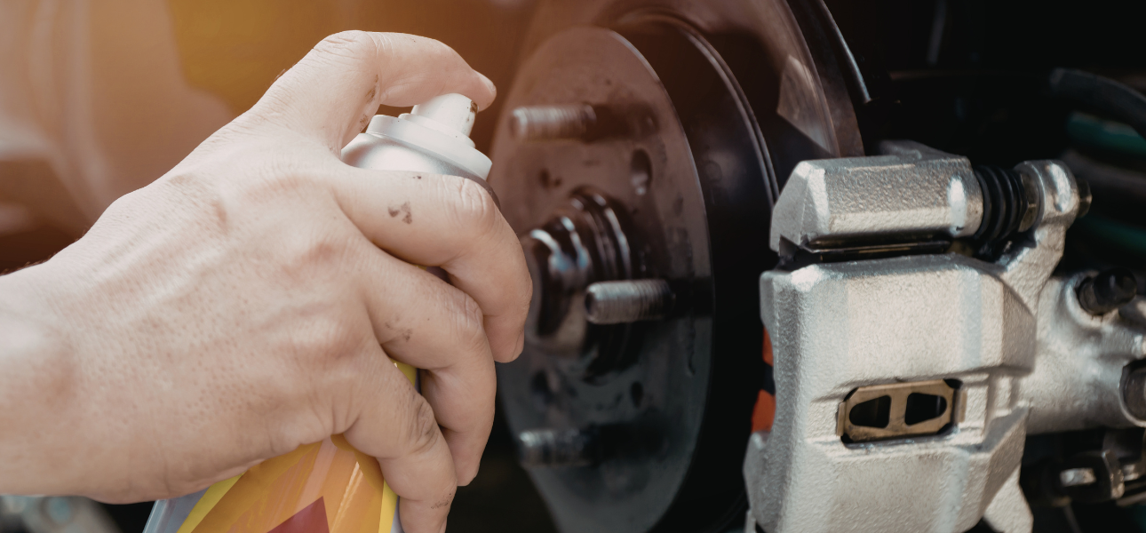 A person sprays cleaner onto a brake