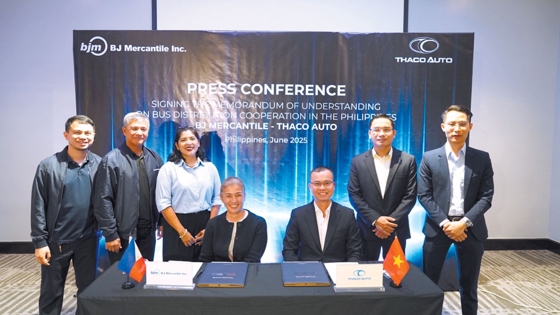 A group of people poses for a photo at a press conference