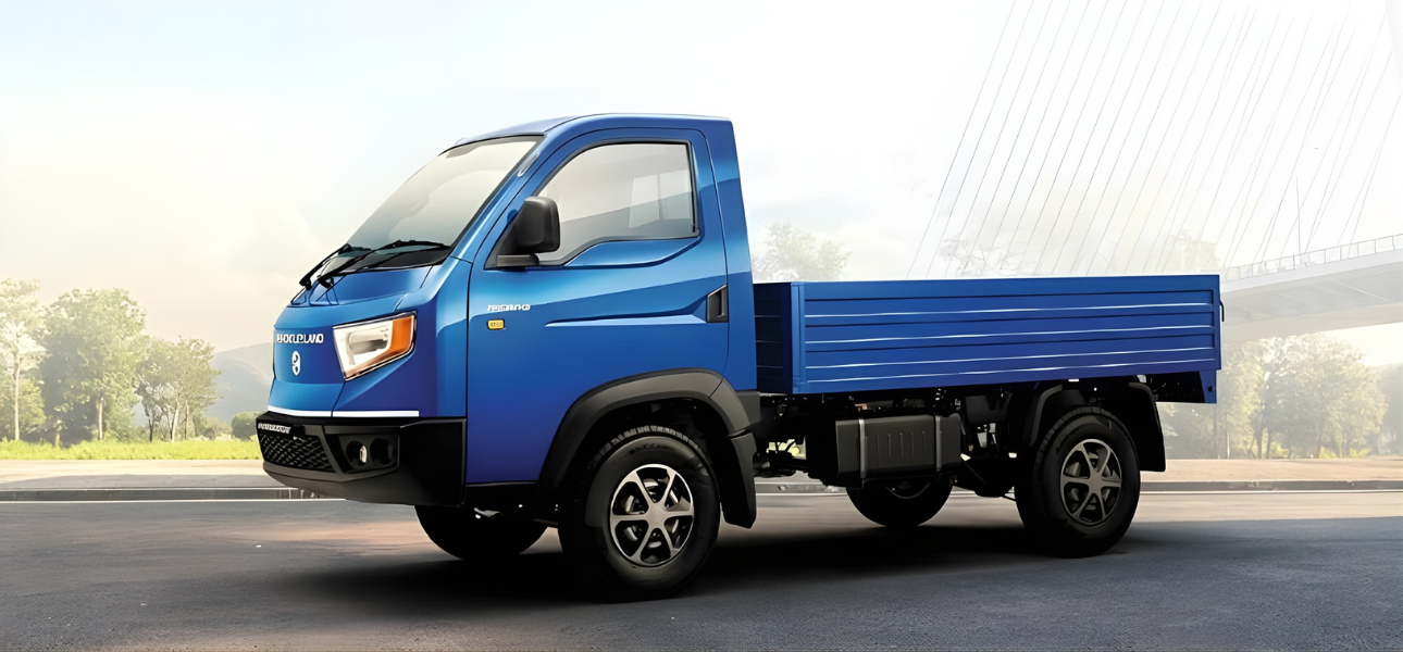 A blue Ashok Leyland Phoenix truck driving on the road under a clear sky.
