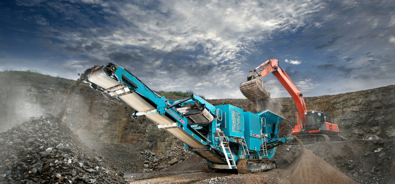 A Scania machine operates on a large pile of dirt, moving and reshaping the earth for construction or landscaping purposes.