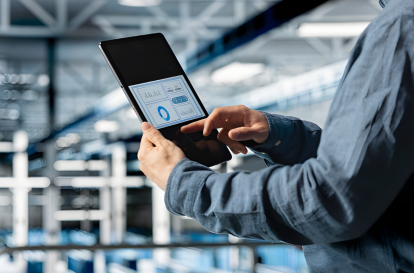 A man using a tablet to track and manage vehicles.