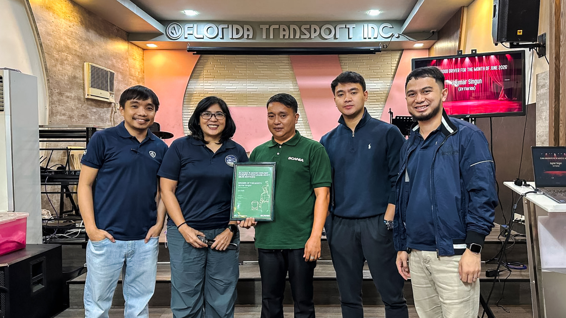 Group photo of Scania Good Driver Competition 2026-2027 winner Jaymar Singun holding his certificate with event organizers at Florida Transport Inc.